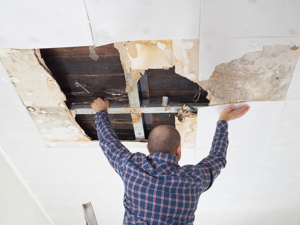 Man repairing collapsed ceiling.